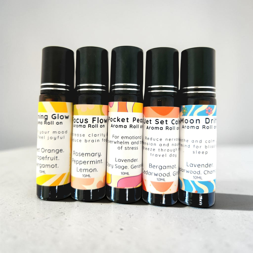 Set of five aroma roll-on bottles with colorful labels on a light gray background