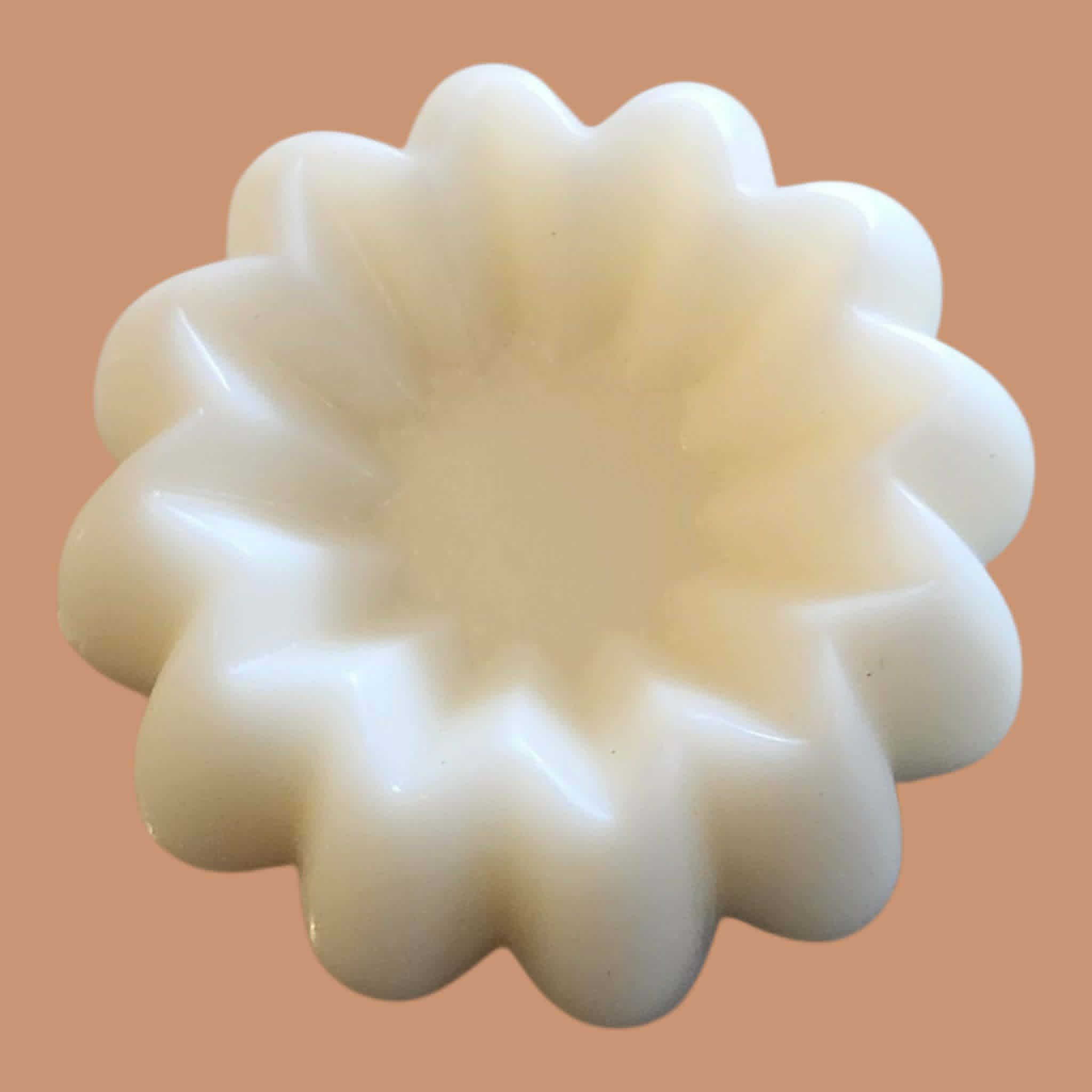 White, flower-shaped object on a peach-colored background