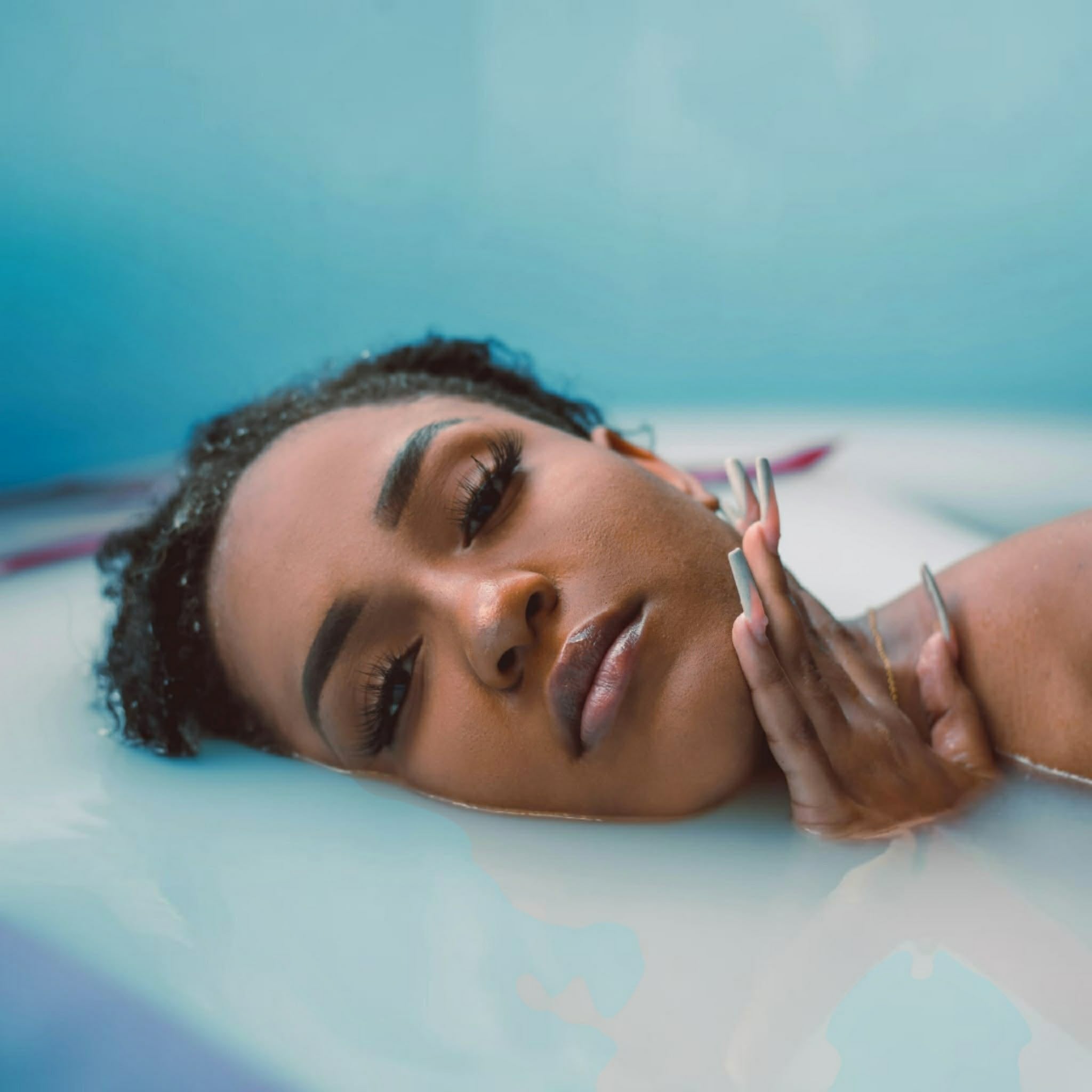 Beautiful woman cleansing in a milk bath