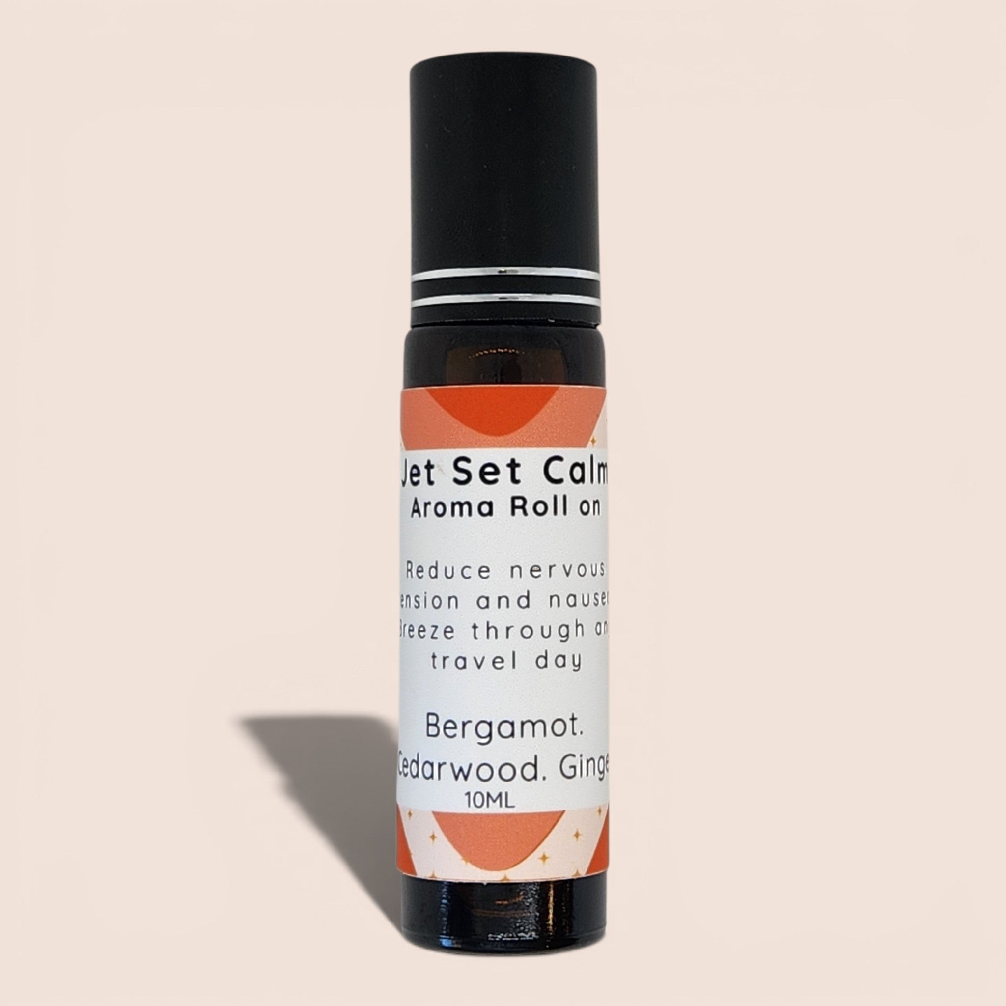A 10ml Bergamot, Cedarwood, and Ginger aroma roll-on bottle with a black cap and a white label featuring orange graphic accents, set against a solid beige background.