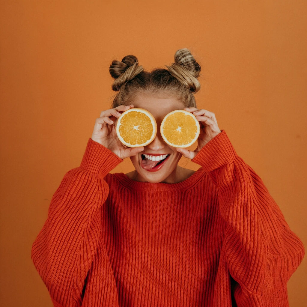 Girl posing with oranges with a orange jumper and orange background