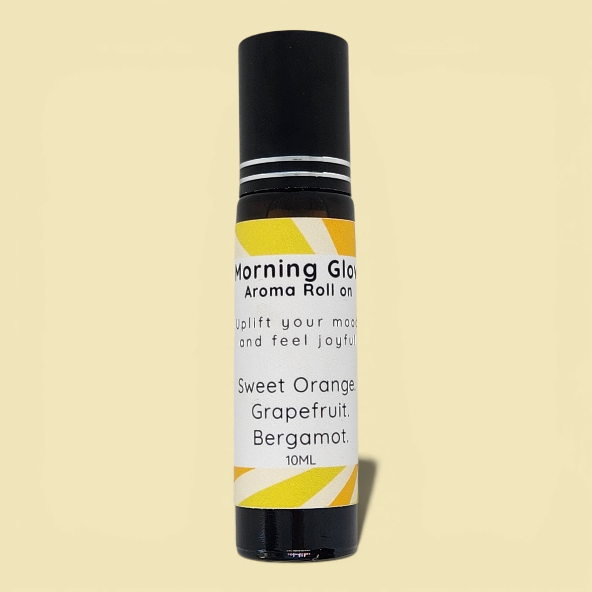 Aroma roll-on bottle labeled 'Morning Glow' with a yellow and black design on a beige background