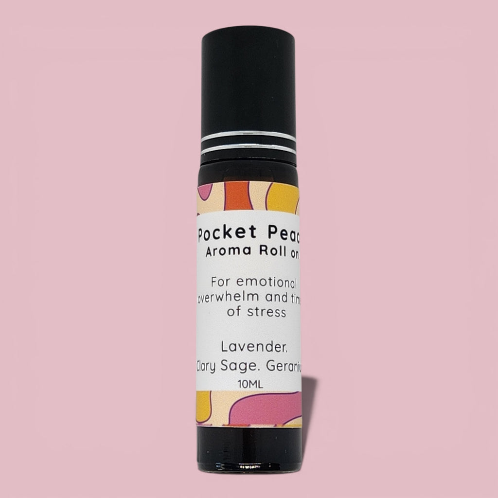 Aroma roll-on bottle with colorful label on a pink background