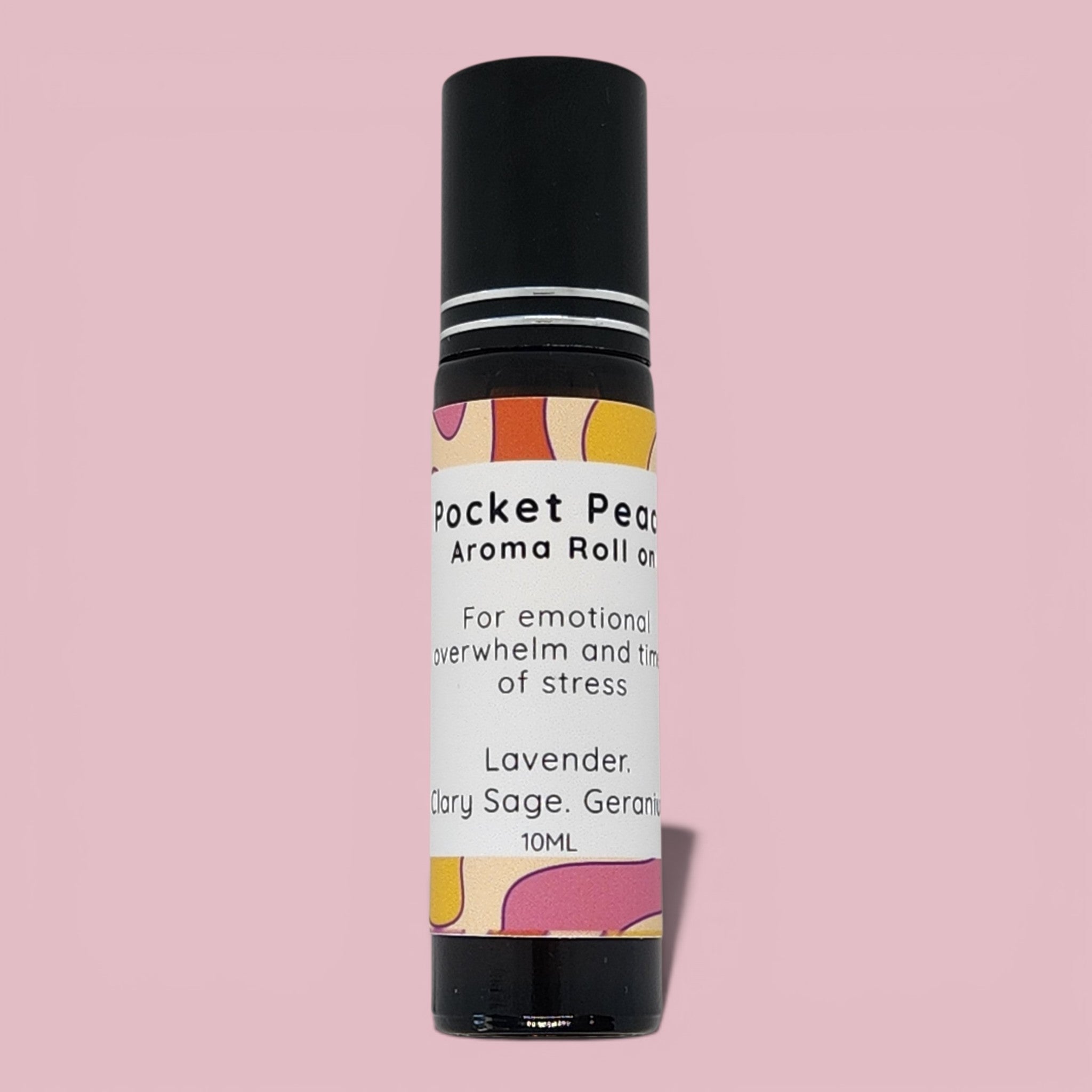 Aroma roll-on bottle with colorful label on a pink background