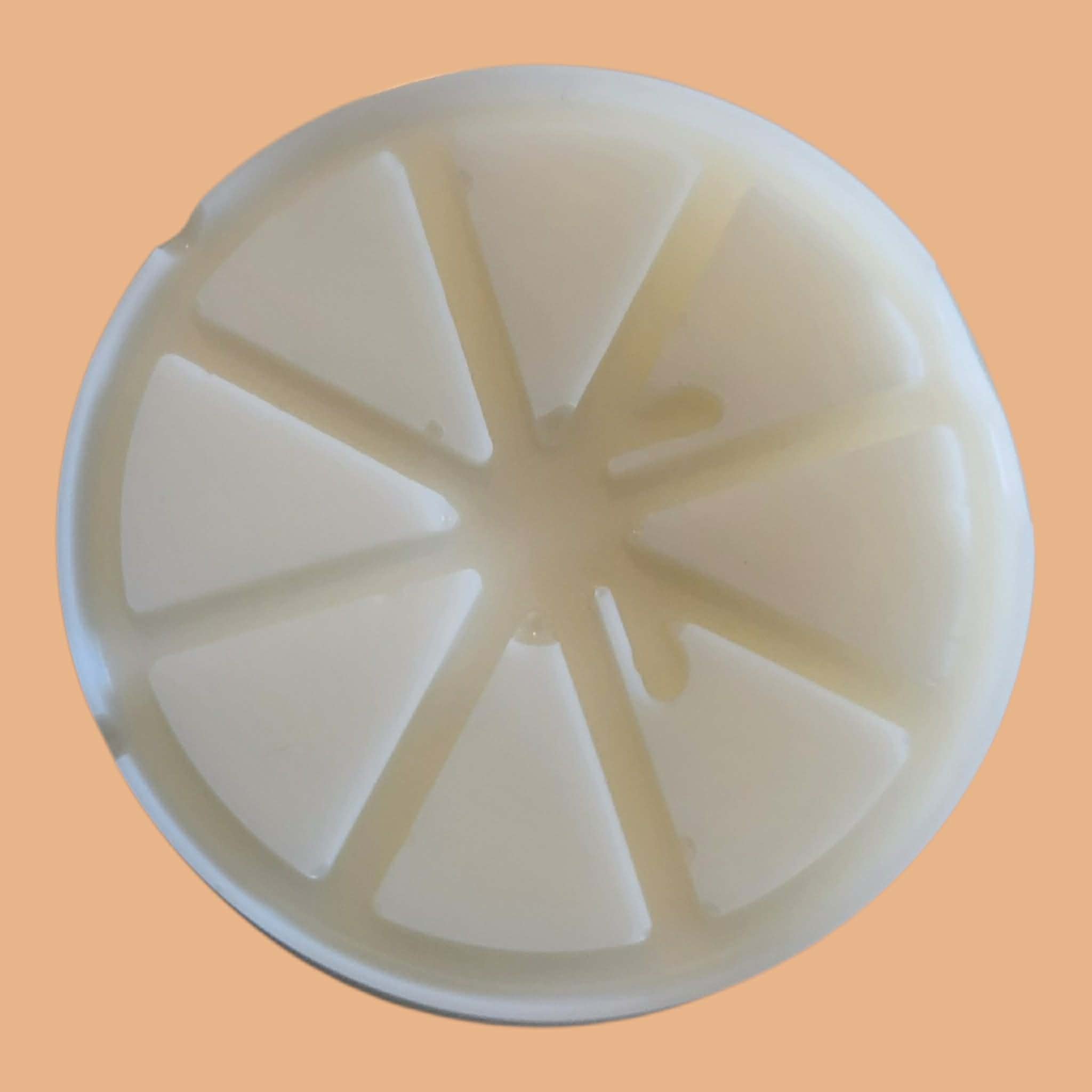 A round, off-white plastic or silicone mold with a segmented, star-like pattern radiating from the center, shown against a solid peach-colored background.